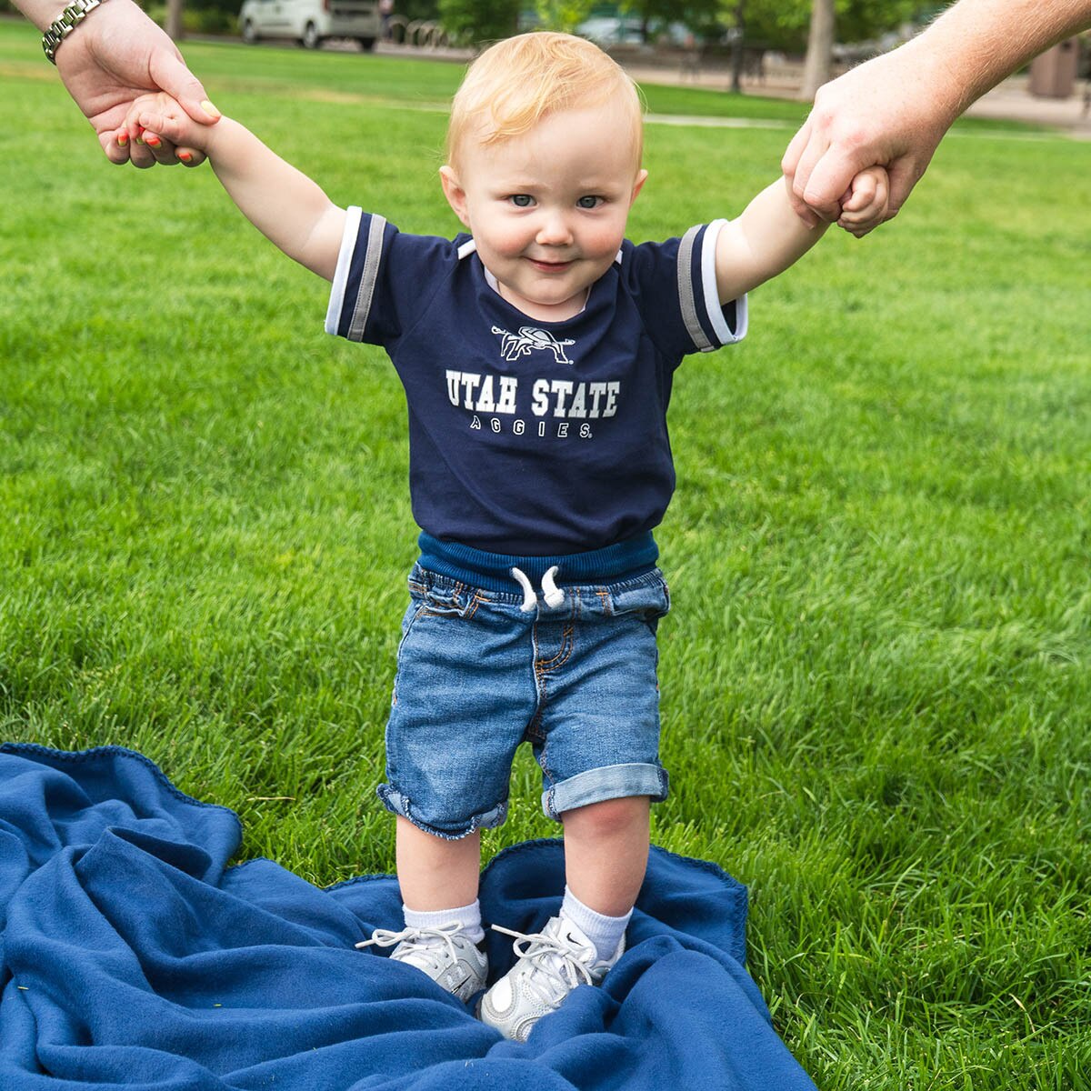 toddler boy wearing utah state aggies onesie on the quad